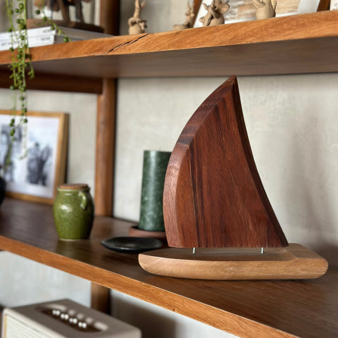 Velero de madera de parota de 1 vela decorando una repisa